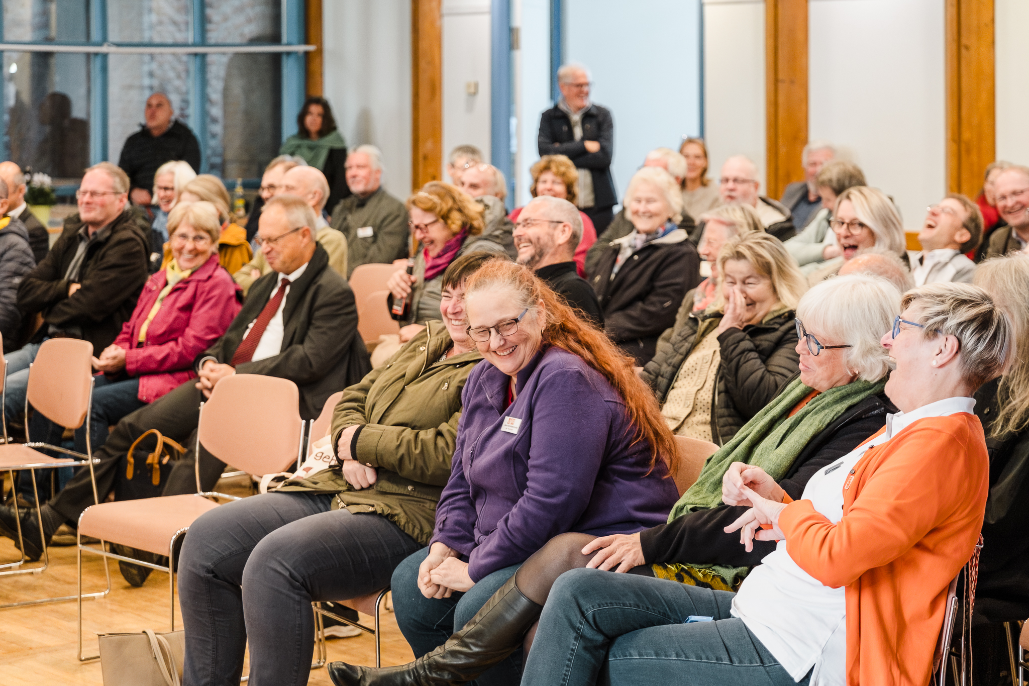 sitzendes, lachendes Publikum im Gemeindesaal der Gustav-Adolf-Kirche Nürnberg